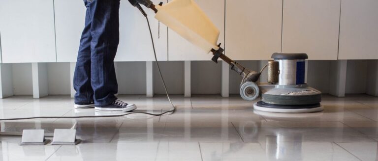 person scrubbing floor using machine